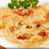 A plate of handmade scallop-filled ravioli with a creamy sun-dried tomato sauce.
