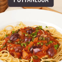 A bowl of spaghetti with puttanesca sauce; tomatoes, Kalamata olives, capers, garlic, onion, and capers.