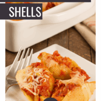 A plate with three sausage stuffed shells topped with marinara and melted cheese.