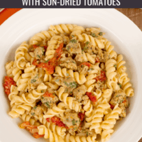 Spiral pasta with crumbled sausage and sun-dried tomatoes.