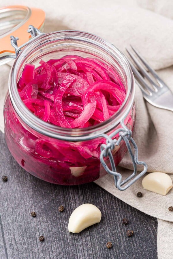 Pickled red onions in an open canning jar.