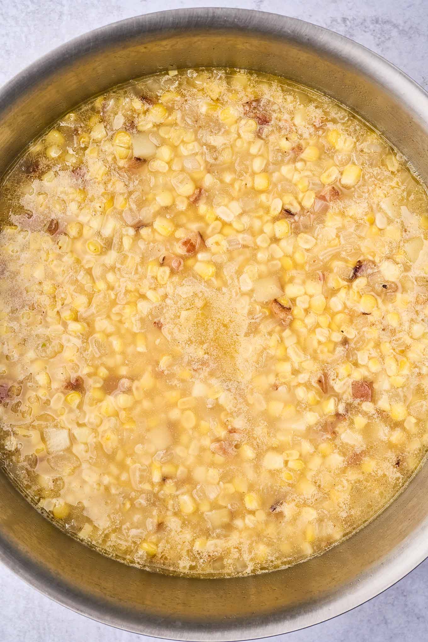Preparing corn chowder; chicken broth, potatoes, and corn, ready to be pureed.