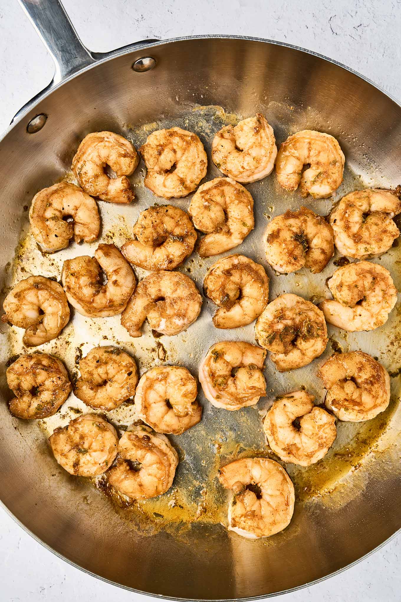 Spicy pan-seared shrimp cooked in a stainless steel skillet, seasoned with smoked paprika, cumin, and cayenne for shrimp tacos.