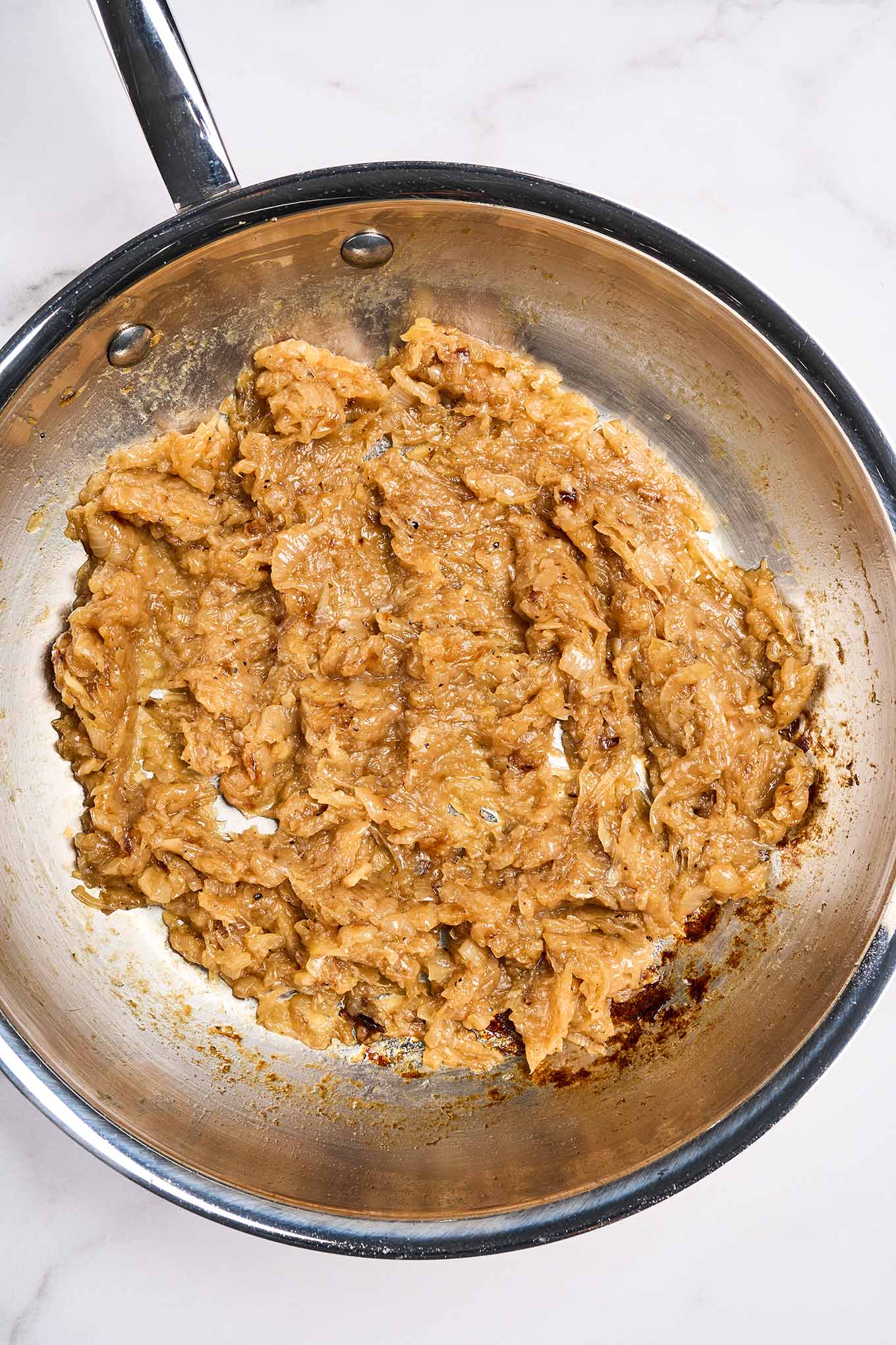 Fully caramelized onions in a stainless skillet, cooked down to a spreadable, jam-like consistency, 45 to 50 minutes.