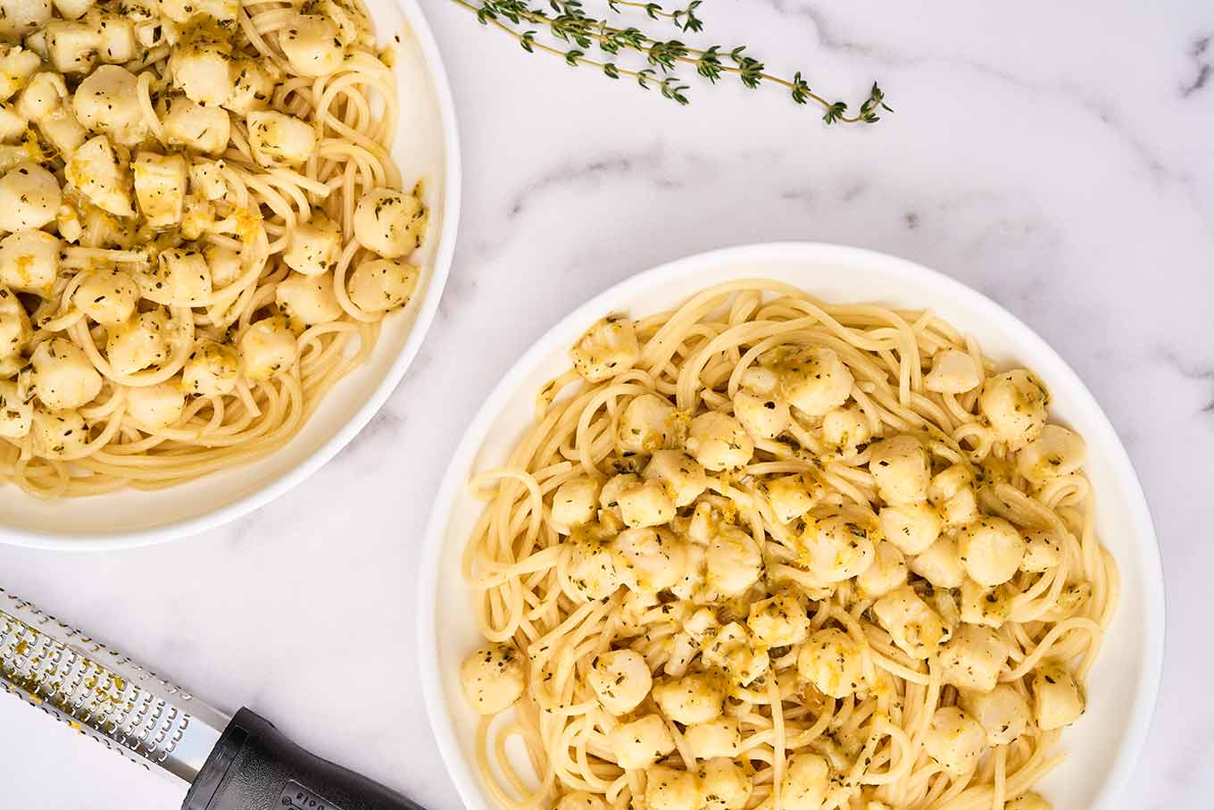 The first dish of the pasta course for this Italian Christmas Eve menu; bay scallops with Sicilian citrus sauce with orange zest, chopped rosemary, and fresh thyme.