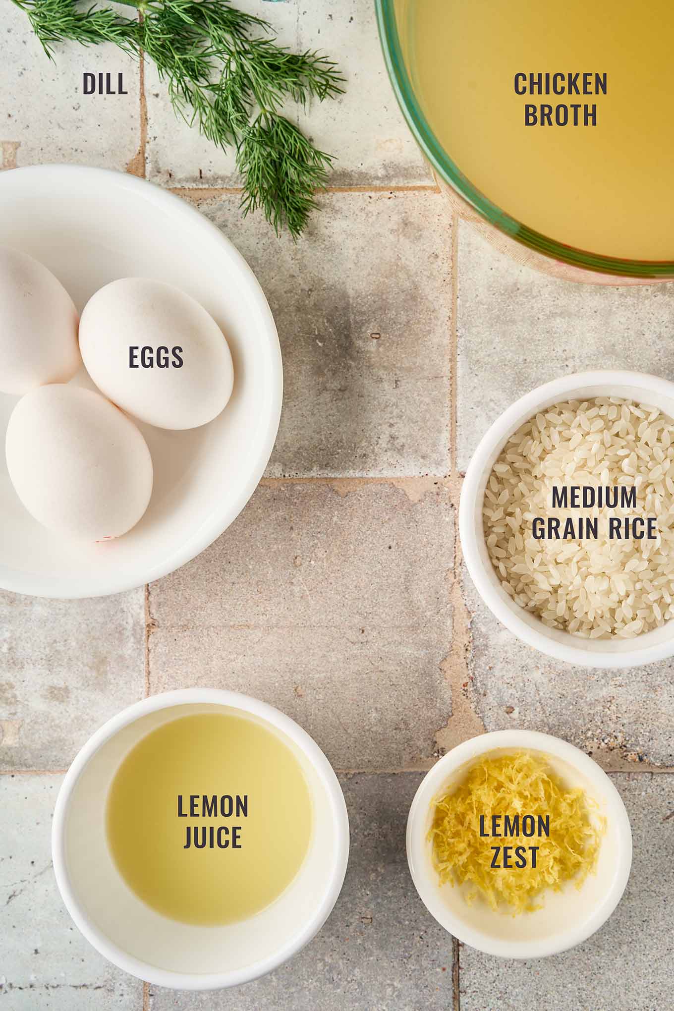 Ingredients for Greek egg and lemon soup including eggs, chicken broth, medium-grain rice, lemon juice, lemon zest, and fresh dill.