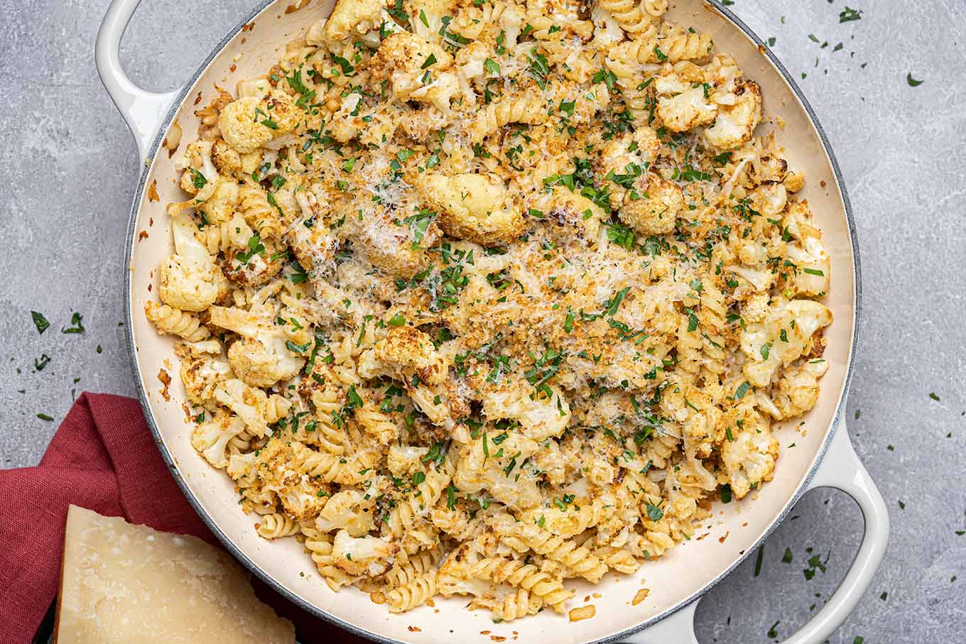 Pasta tossed with roasted cauliflower, toasted panko and pine nuts, Parmesan cheese, and parsley in a skillet.