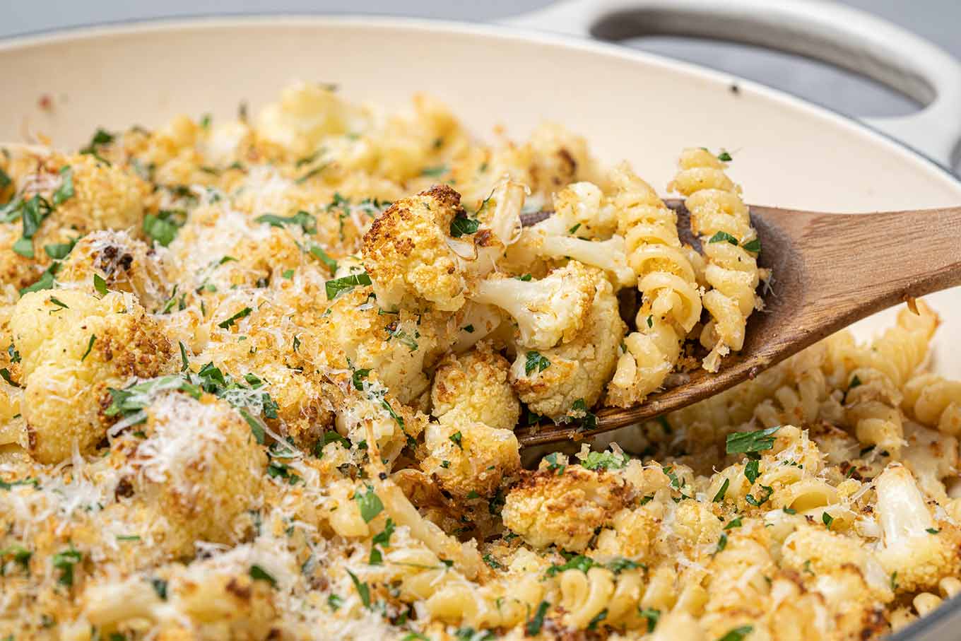 Close-up of roasted cauliflower pasta with toasted breadcrumbs, pine nuts, parsley, and grated Parmesan.
