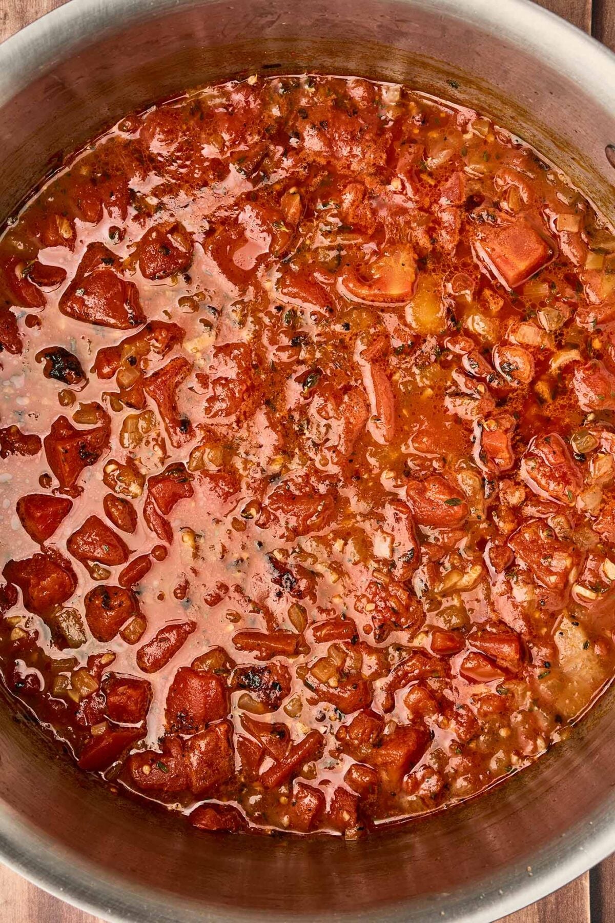 Fire-roasted tomatoes and chicken broth simmering with saut&eacute;ed onions and thyme for tomato and bacon soup.
