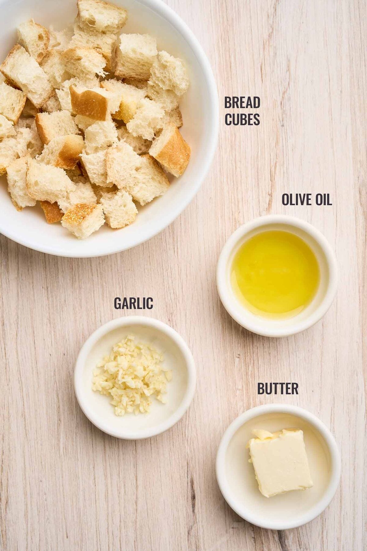Ingredients for garlic croutons for warm Brussels sprouts Caesar salad including bread cubes, garlic, butter, and olive oil.