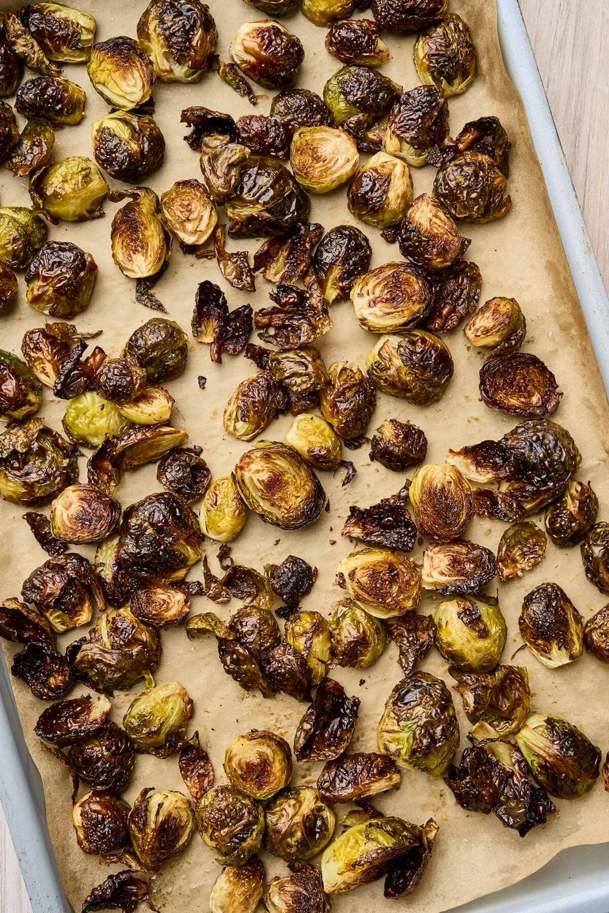 Roasted Brussels sprouts with browned edges on a parchment-lined baking sheet.