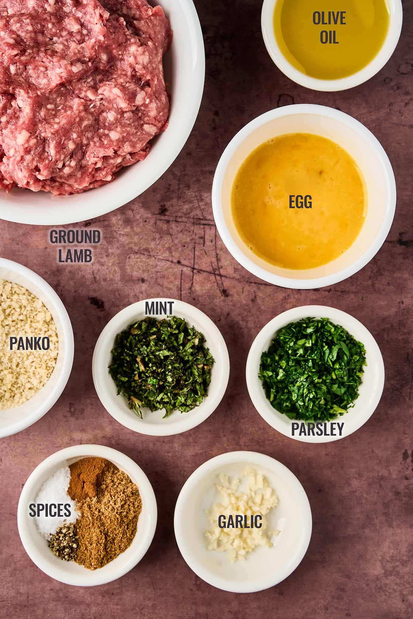 Ingredients for Moroccan meatballs in tomato sauce including ground lamb, egg, olive oil, panko, garlic, mint, parsley, and spices.