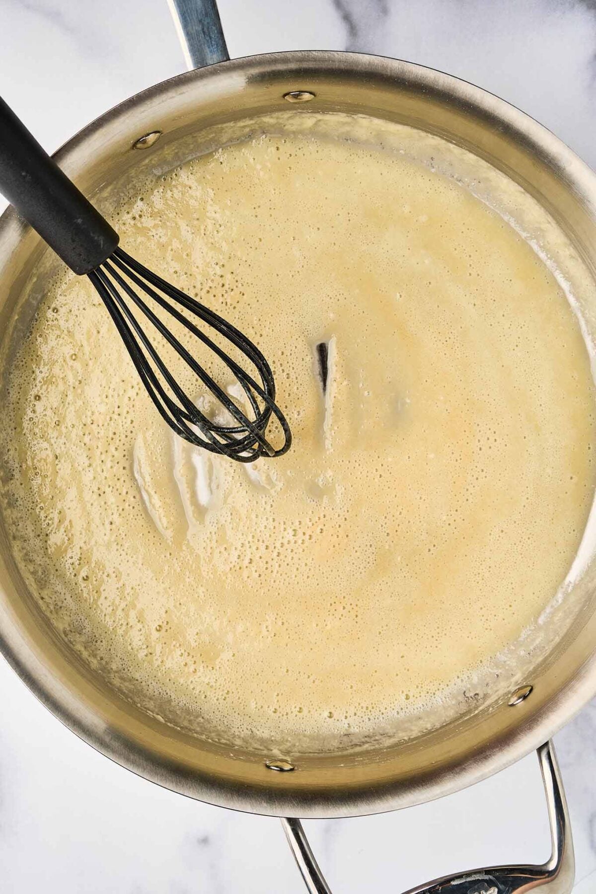 Butter and flour roux being whisked for b&eacute;chamel sauce in French macaroni and cheese.