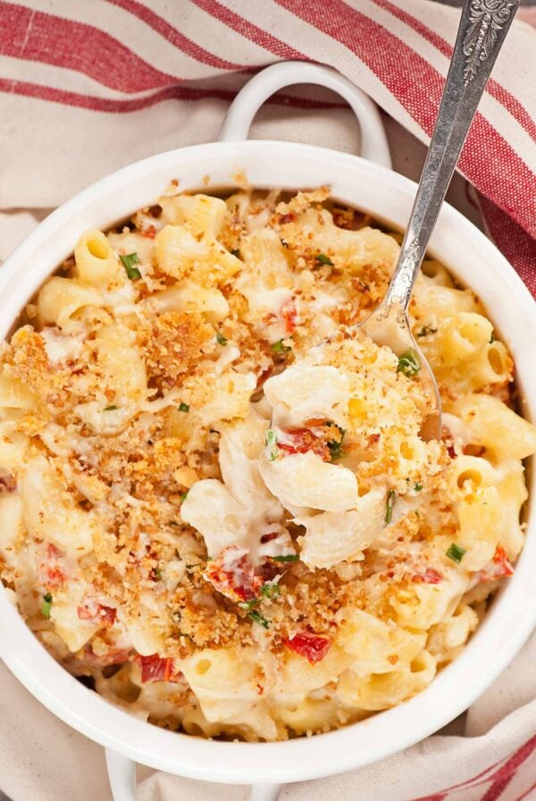 Goat cheese and sun-dried tomato mac and cheese with garlic breadcrumb topping in a white baking dish.