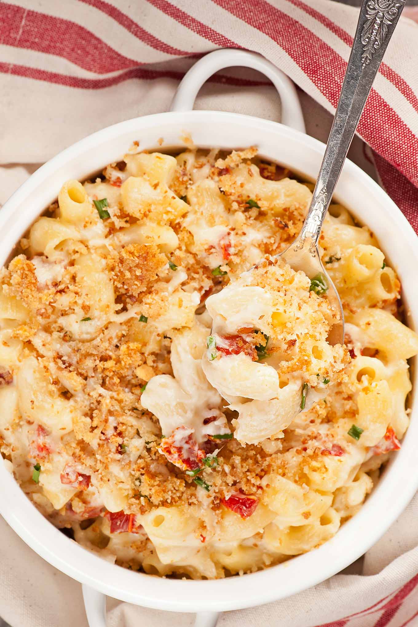 Goat cheese and sun-dried tomato mac and cheese with garlic breadcrumb topping in a white baking dish.