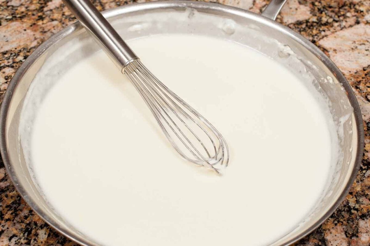 Smooth béchamel sauce thickened and ready for cheese in homemade macaroni and cheese.