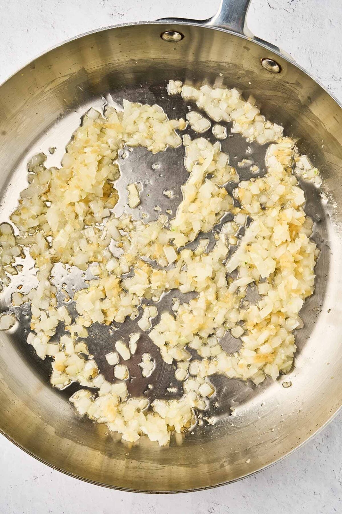 Onion, garlic, and fresh ginger saut&eacute;ing in oil for coconut curry salmon.