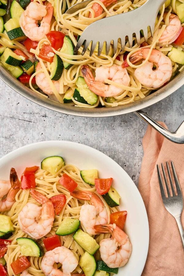 Shrimp and zucchini pasta with linguine, red bell pepper, and saut&eacute;ed zucchini served in a bowl and skillet.