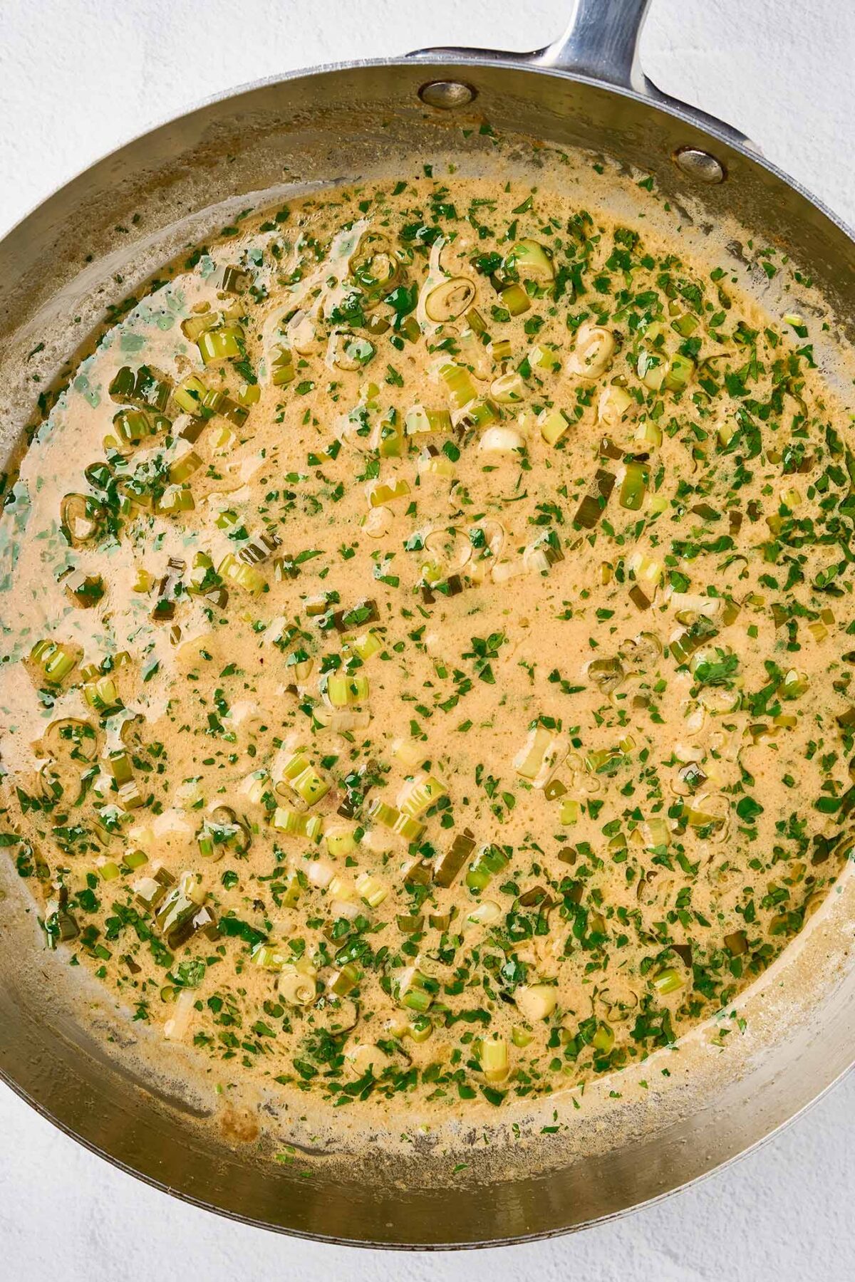 Creamy cilantro lime sauce simmering in a skillet before the chicken is returned to the pan.