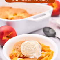 Fresh peach cobbler with buttery biscuit topping and vanilla ice cream served in a white bowl.