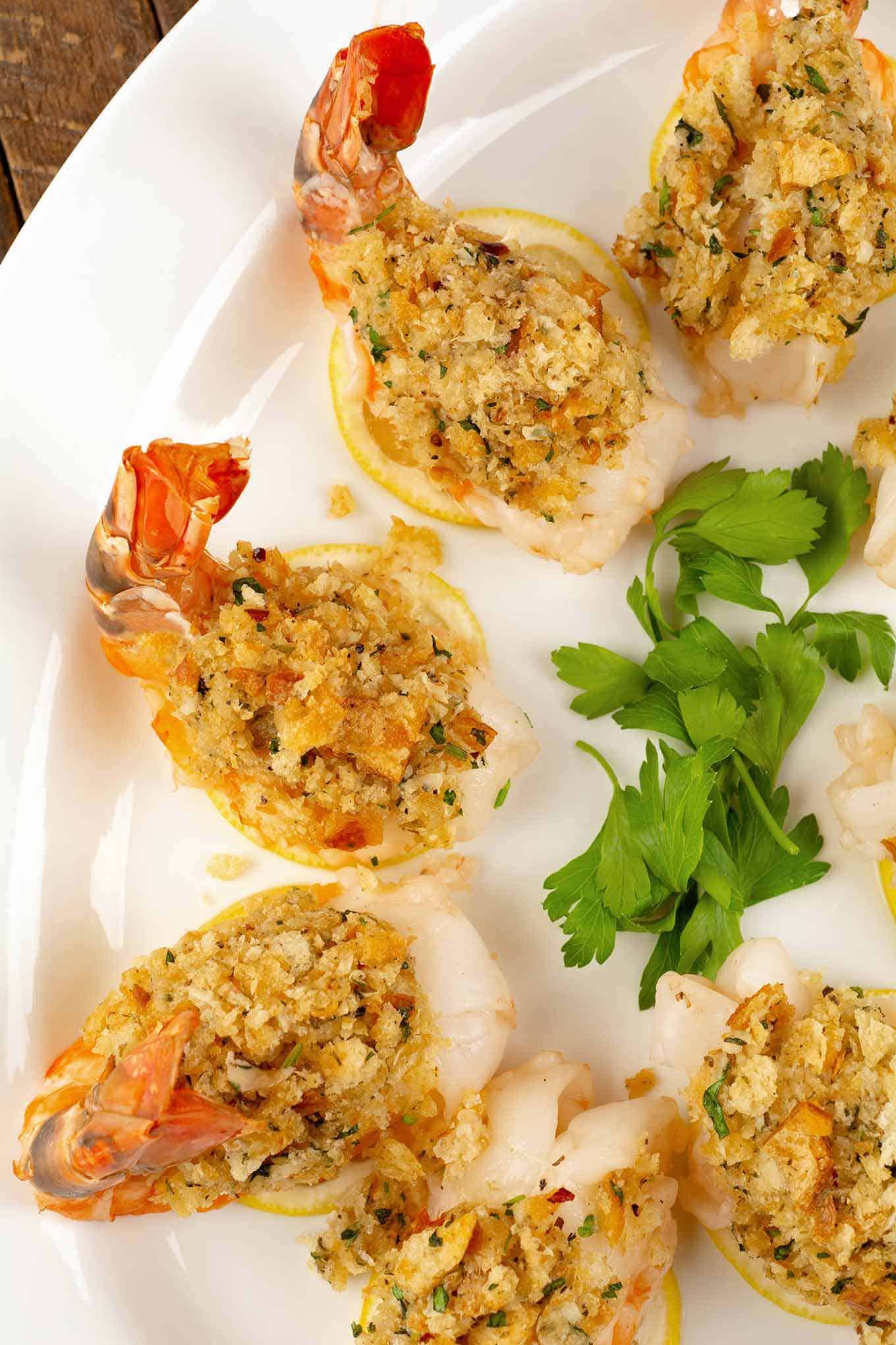 Serving platter of baked stuffed shrimp on lemon slices