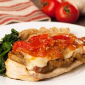 Plate of Chicken Sorrentino - chicken breast topped with eggplant, melted cheese, and tomato sauce, served with sautéed spinach and pasta shells.