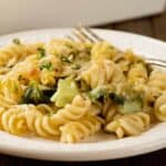 A close-up photo of rotini pasta tossed with sautéed escarole and a creamy, garlic and Parmesan cheese sauce.
