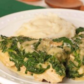 Easy chicken Florentine topped with creamy spinach sauce, served with a side of mashed potatoes on a white plate.