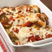 Baked Italian-style eggplant casserole in a white dish, layered with tomato sauce and melted mozzarella cheese.