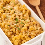 Baked cavatappi pasta with cabbage and thyme in a white casserole dish, topped with melted Parmesan cheese and parsley.