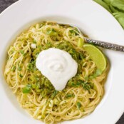 Thin spaghetti tossed with a salsa verde made with tomatillos, poblano peppers, lime, scallions, and cilantro, garnished with sour cream and a lime wedge.