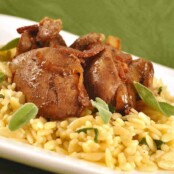 Sautéed chicken livers with caramelized onions, crispy bacon, and fresh sage on a bed of orzo pasta, served on a white plate.