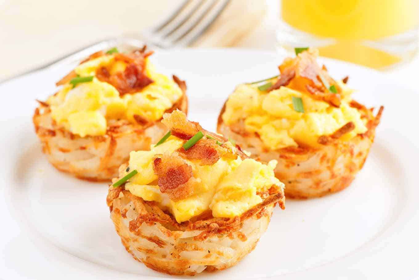 Plate with three potato nests filled with scrambled eggs and bacon