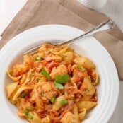 A bowl of Sicilian pasta with cauliflower; shell pasta combined with steamed cauliflower, raisins, pine nuts, diced tomatoes, and anchovies.