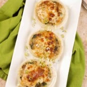 An overhead view of baked sweet onion halves filled with creamy sautéed fresh spinach and mushrooms and topped with melted cheese.