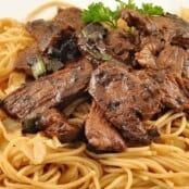 Stir-fried steak with black garlic sauce served over noodles