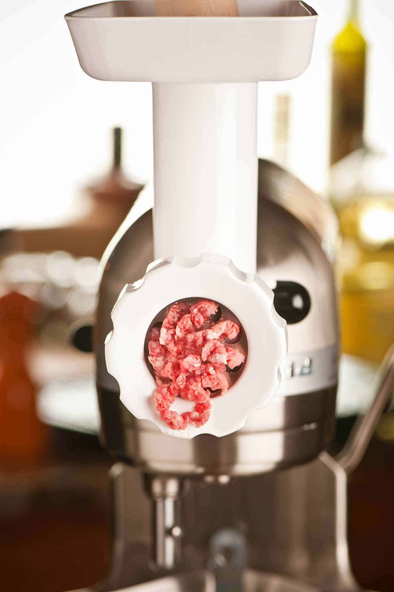 An electric meat grinder being used to make fresh ground beef.